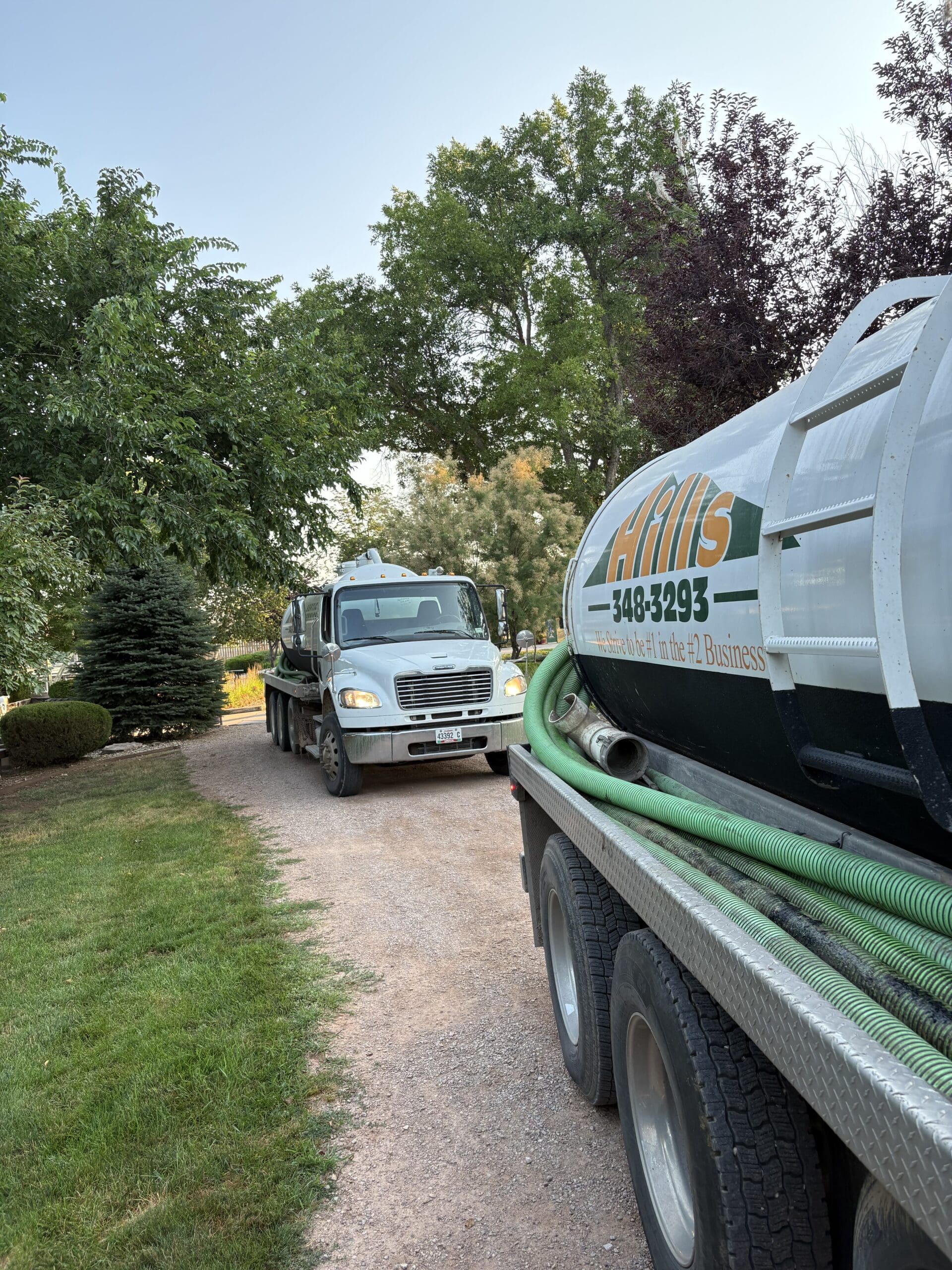 Two Hills Septic Service Trucks in a driveway